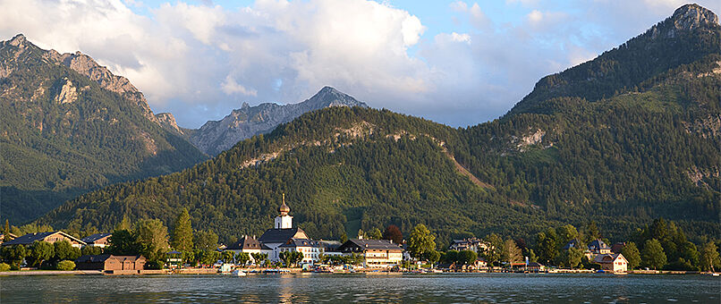 View of the village Strobl at sundown across lake Wolfgang with mountains in the background.